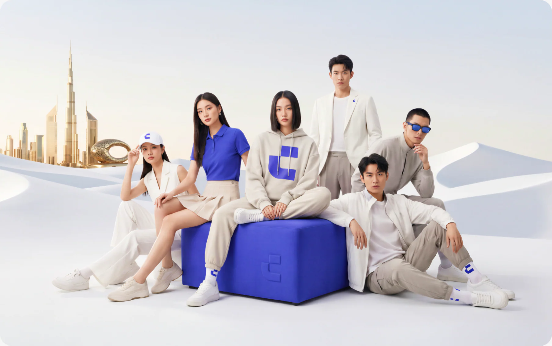 CoinW apparel campaign with models in a desert landscape and branded blue cube