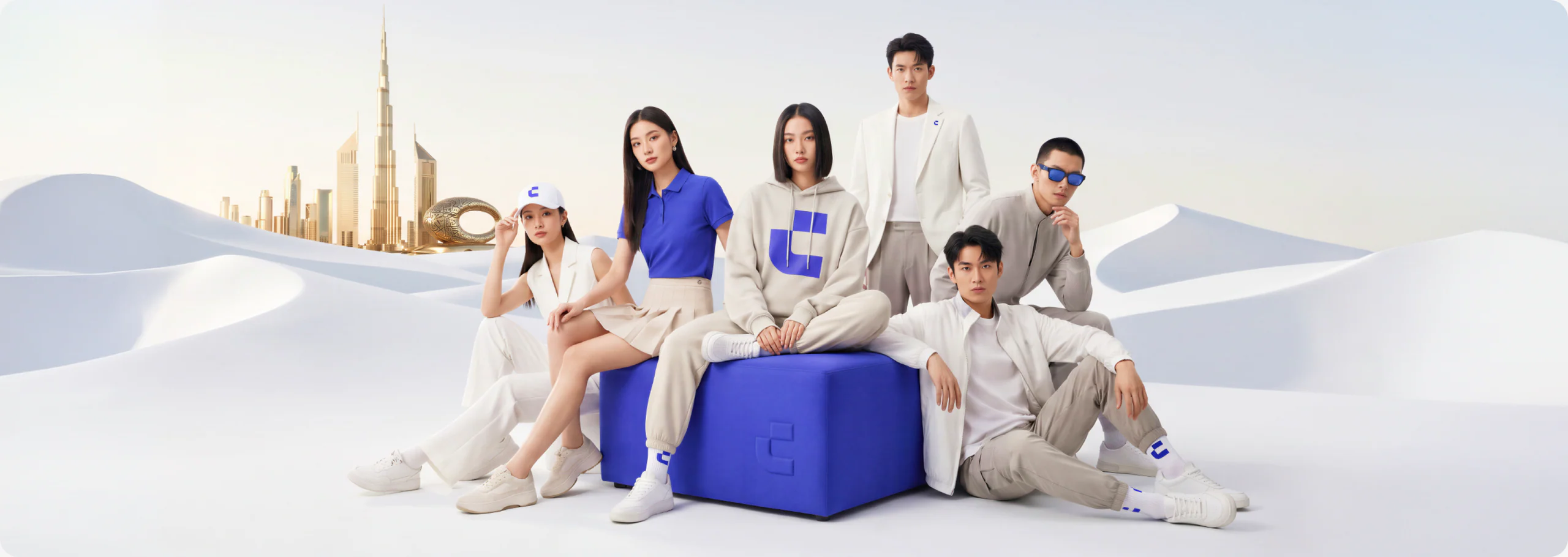 CoinW apparel campaign with models in a desert landscape and branded blue cube